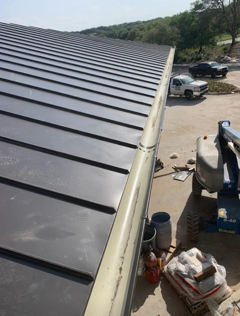 Standing seam panel and gutter detail on a metal roofing jobsite in Jefferson City